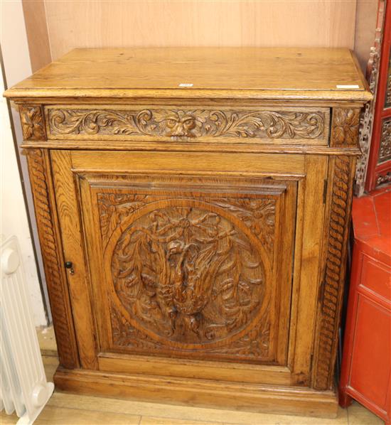 A carved oak cupboard W.92cm